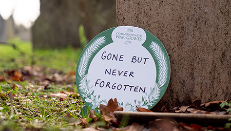 Tribute next to a grave with the words 'gone but never forgotten'